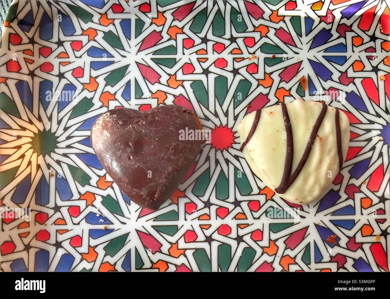 Two sweet heart chocolate treats on a colourful tray. - Smartphone Captured Stock Image