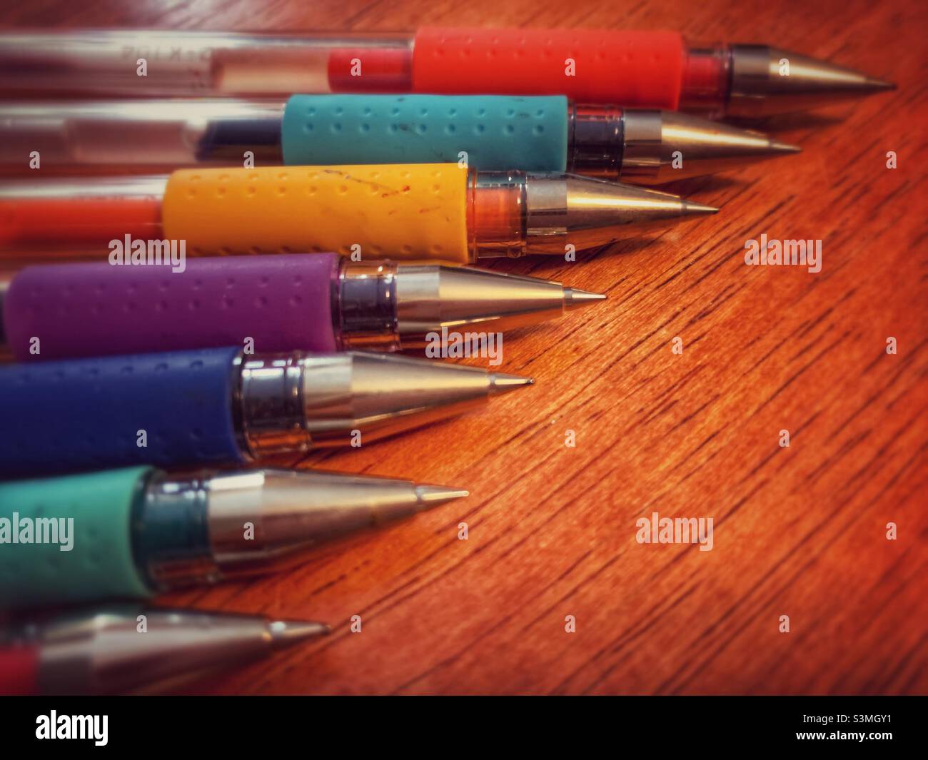 Organized colorful pens against brown background. - Smartphone Captured Stock Image