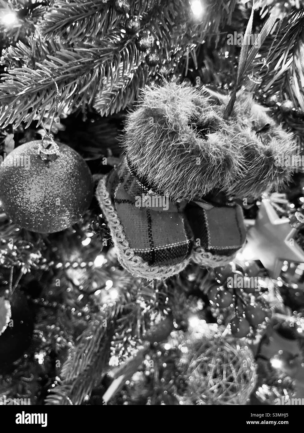 Black and white image of cute boots on a decorated Christmas tree Stock Photo