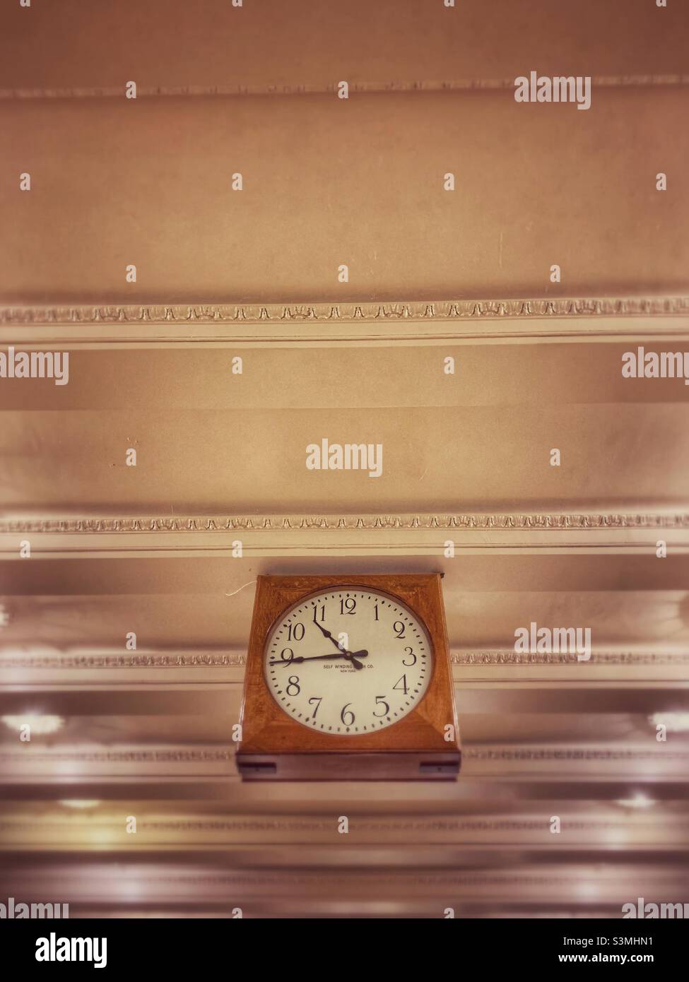 Brown clock hanging from the ceiling. - Smartphone Captured Stock Image