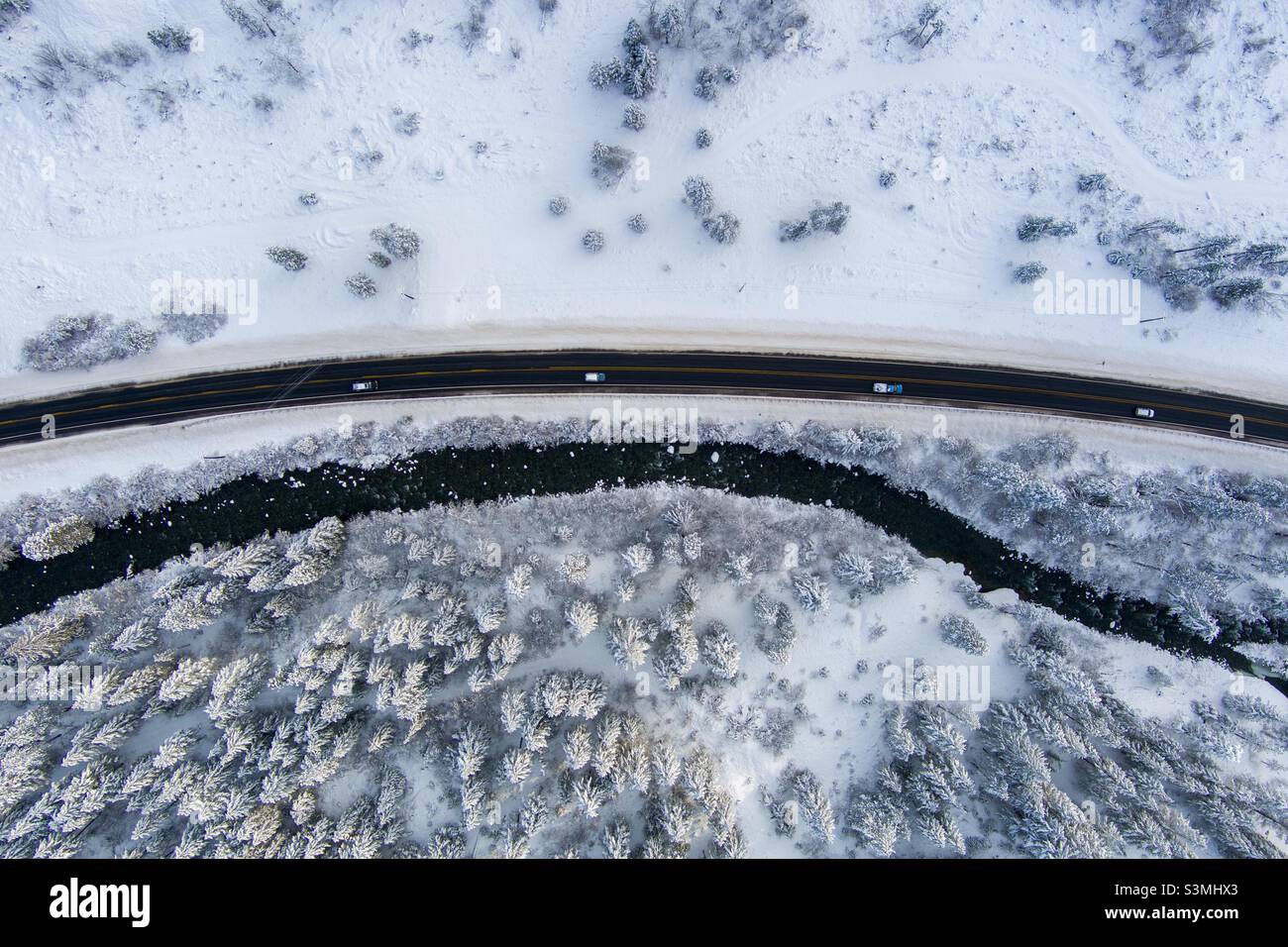 Aerial view of a highway along a river in the snow covered cascade mountains - Smartphone Captured Stock Image