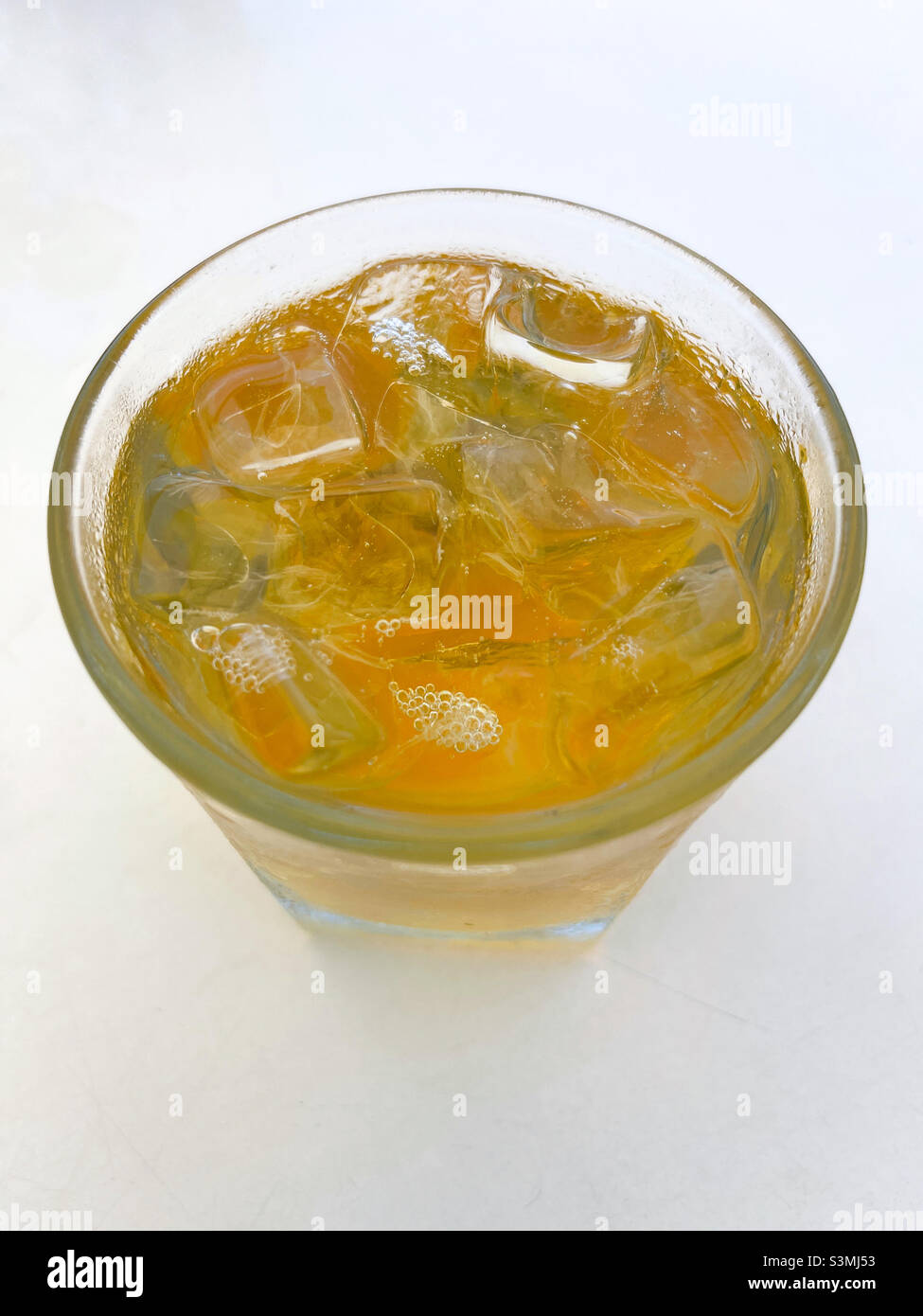 A glass of ginger ale on white table Stock Photo