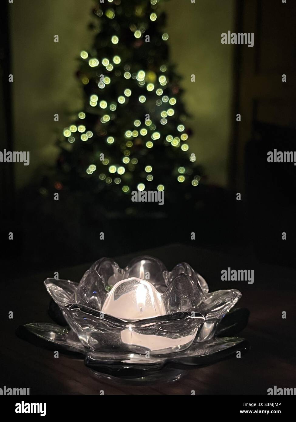 Lotus shaped crystal candle holder in front of the Christmas tree Stock Photo