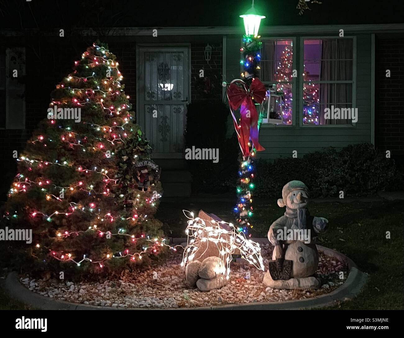 A home in the Salt Lake valley of Utah, USA has their outdoor Christmas decorations up and glowing for the season. - Smartphone Captured Stock Image