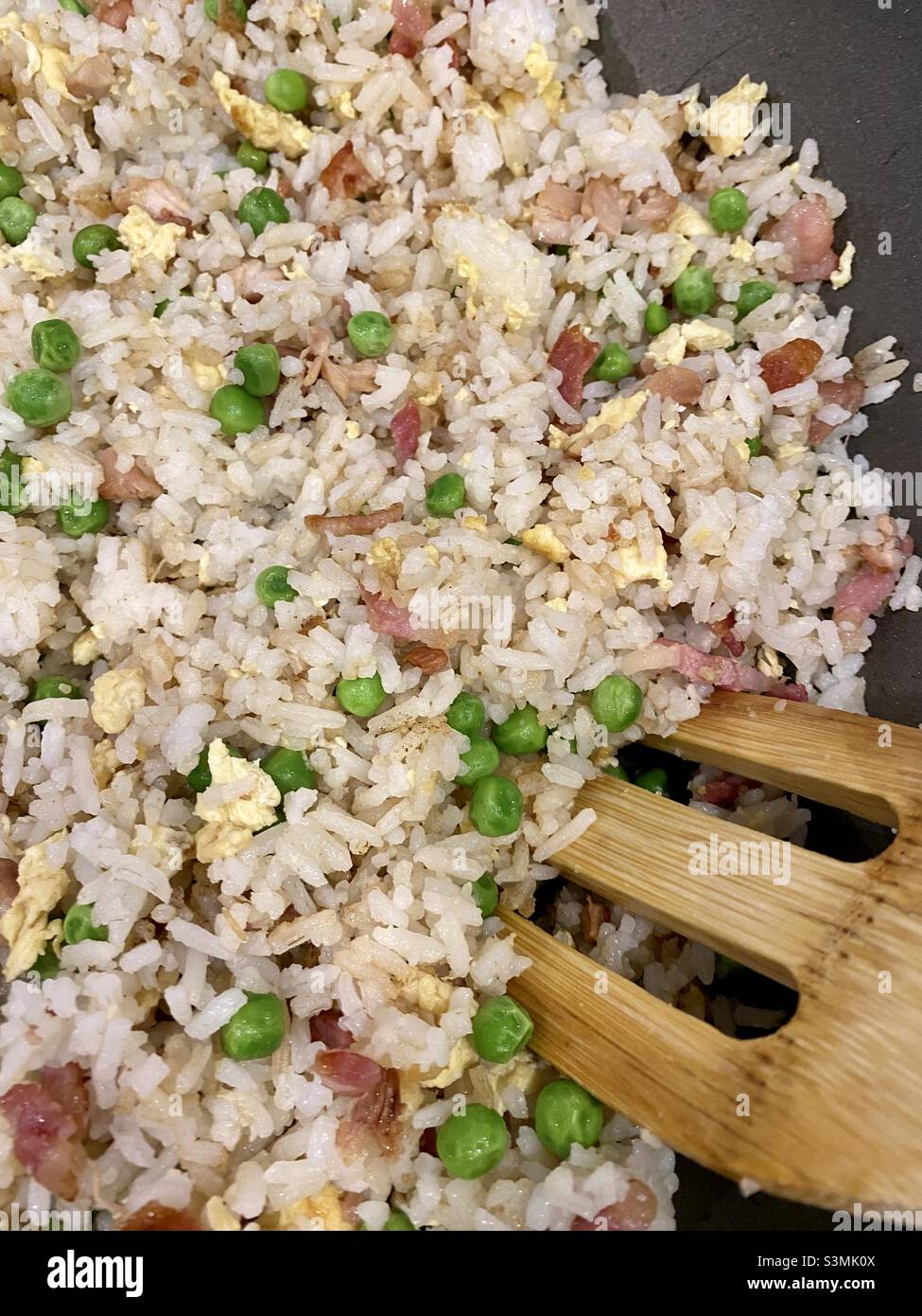 Special fried rice with peas chicken egg being cooked in a wok with