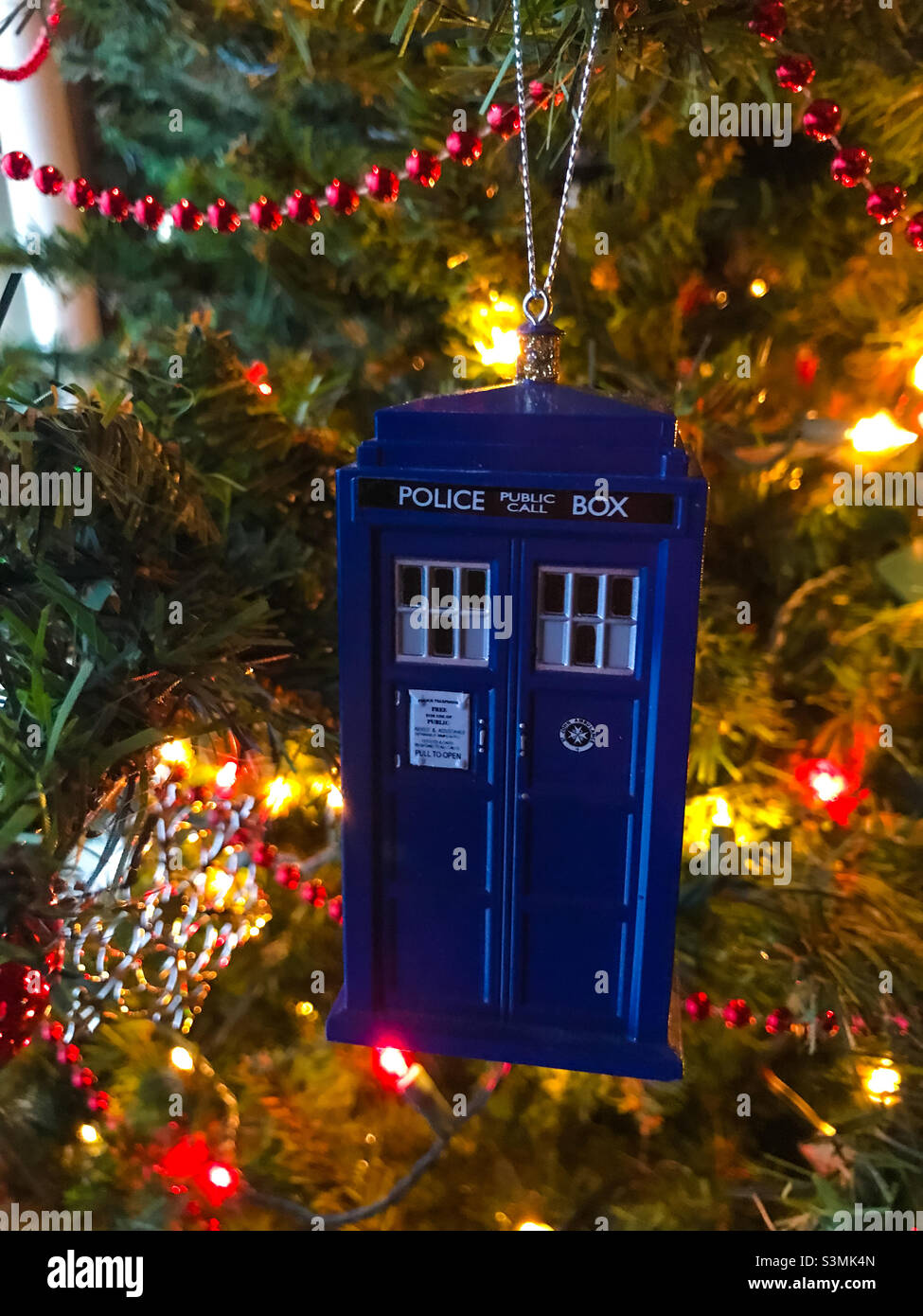 Doctor Who TARDIS ornament hanging on a Christmas tree. - Smartphone Captured Stock Image