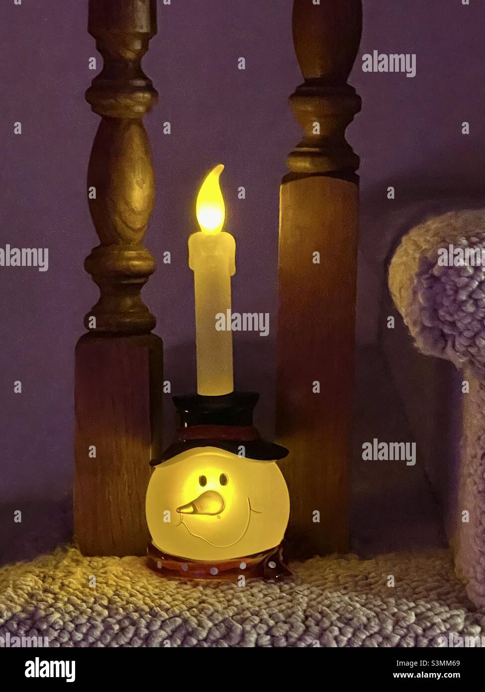 Lighted snowman candle decoration for the Christmas season adds a cheery accent to a staircase in a home in Utah, USA. - Smartphone Captured Stock Image Lighted snowman candle decoration for the Christmas season adds a cheery accent to a staircase in a home in Utah, USA. - Smartphone Captured Stock Image