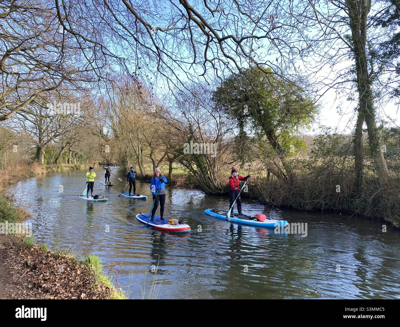 Paddle boarders make their way along Basingstoke Canal in Hampshire, January 2022. Stock Photo