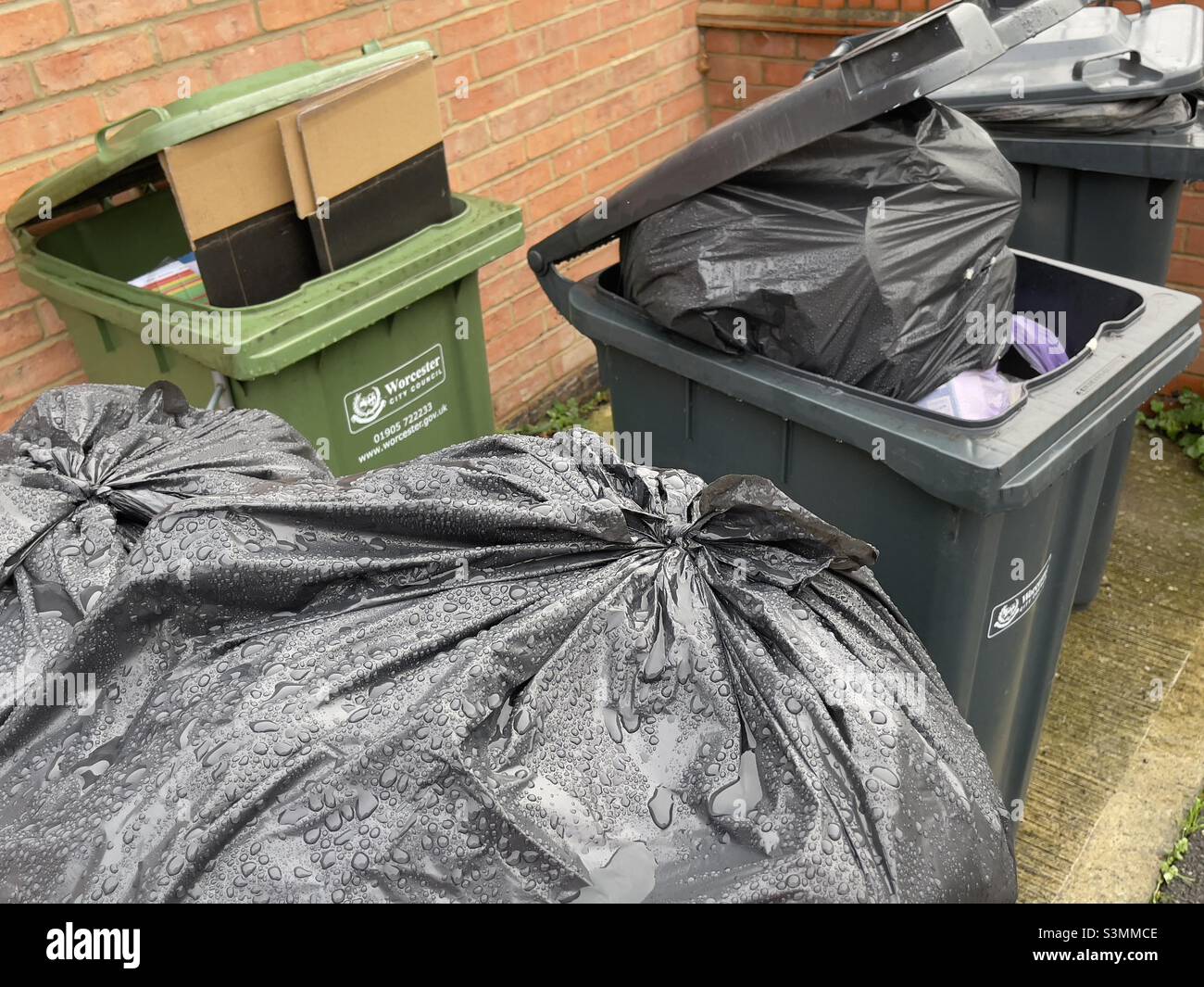 Overloaded dustbins waiting for collection in a Worcester suburb - Smartphone Captured Stock Image