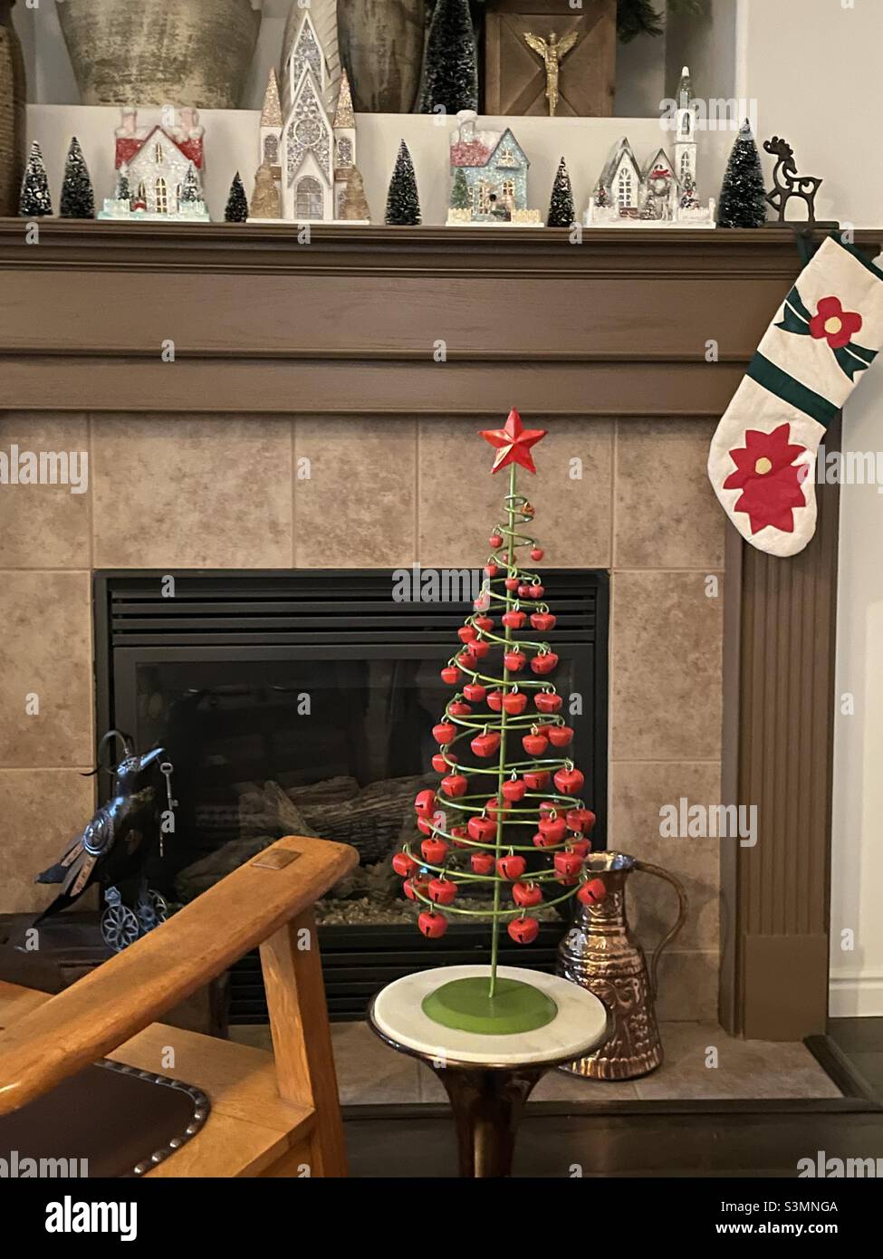 Seasonal home decor decorates a home during the Christmas season, both above the fireplace and around the hearth, making a cozy, cheery and warm living space. - Smartphone Captured Stock Image