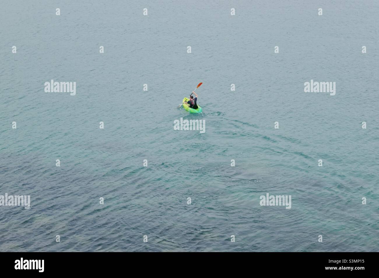 Man kayaking out towards sea to escape for a while Stock Photo