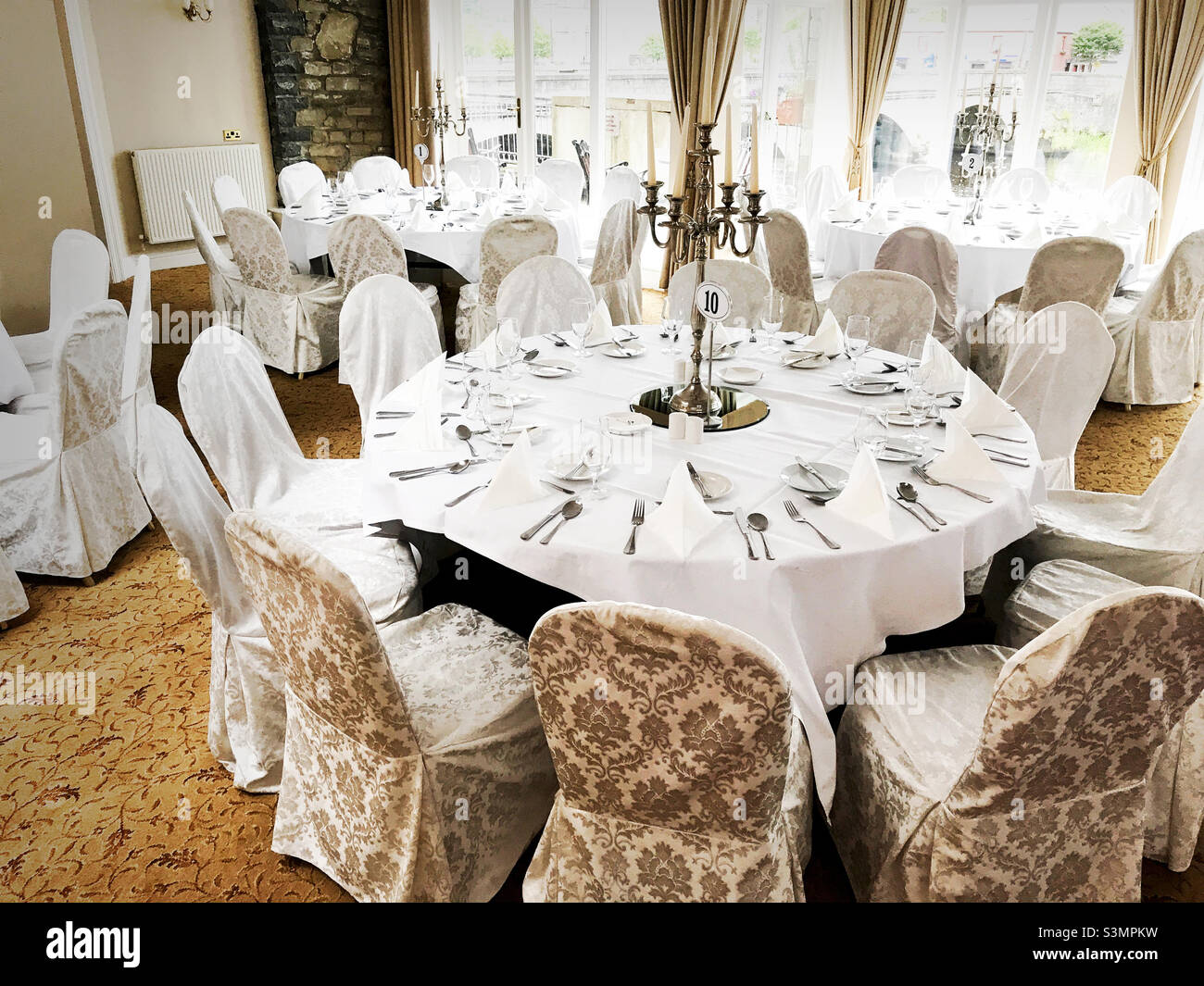 Indoor dining room with white linen place settings Stock Photo - Alamy