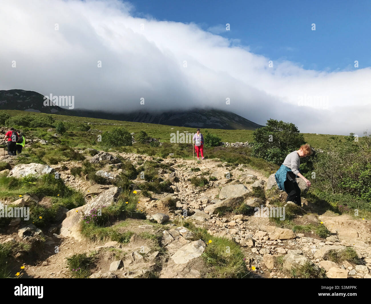 Croagh Patrick Holy Mountain in County Mayo. Tourists enjoy a summer day hiking on the rocks. Stock Photo