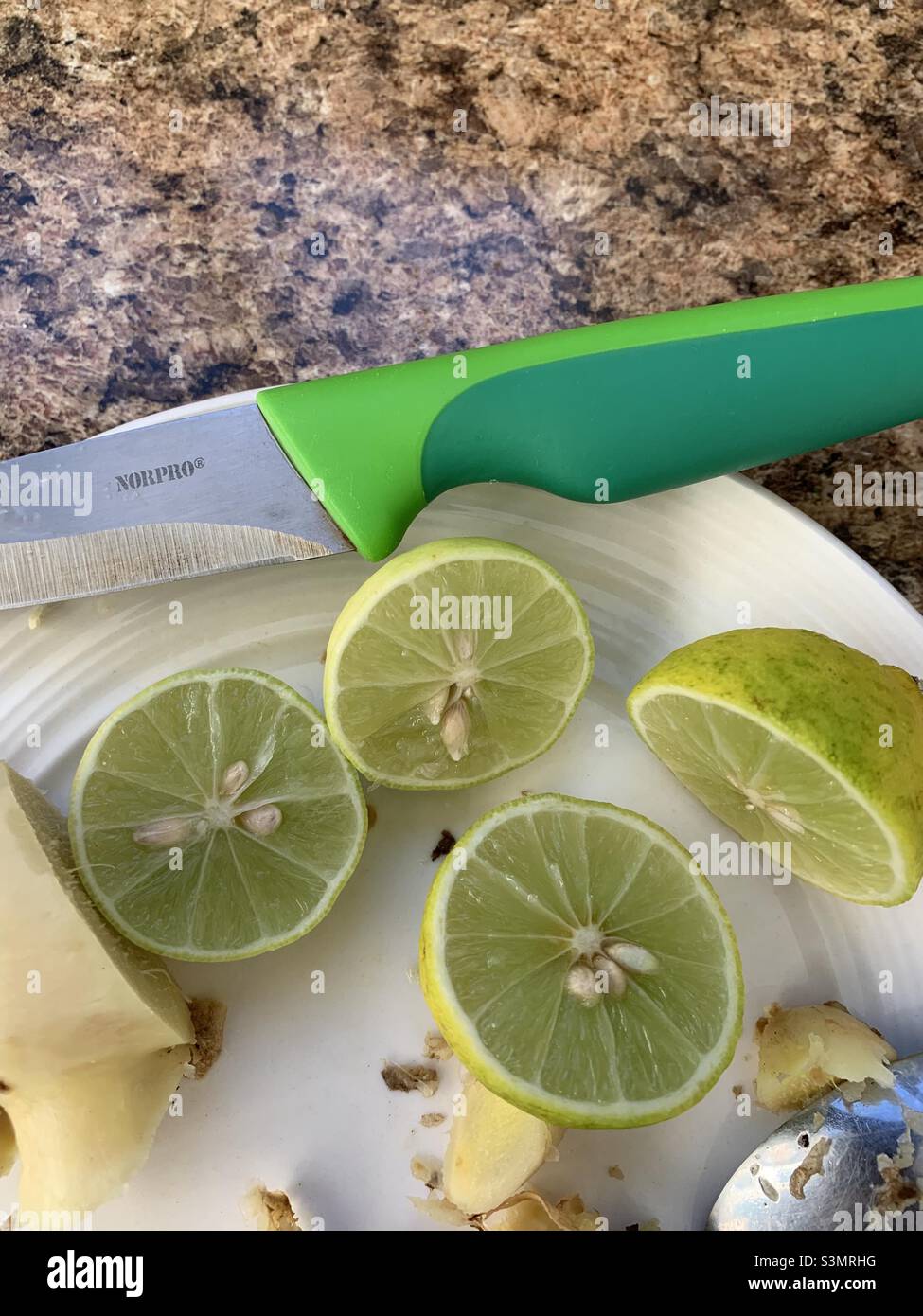 Lime halves with ginger and knife Stock Photo Alamy