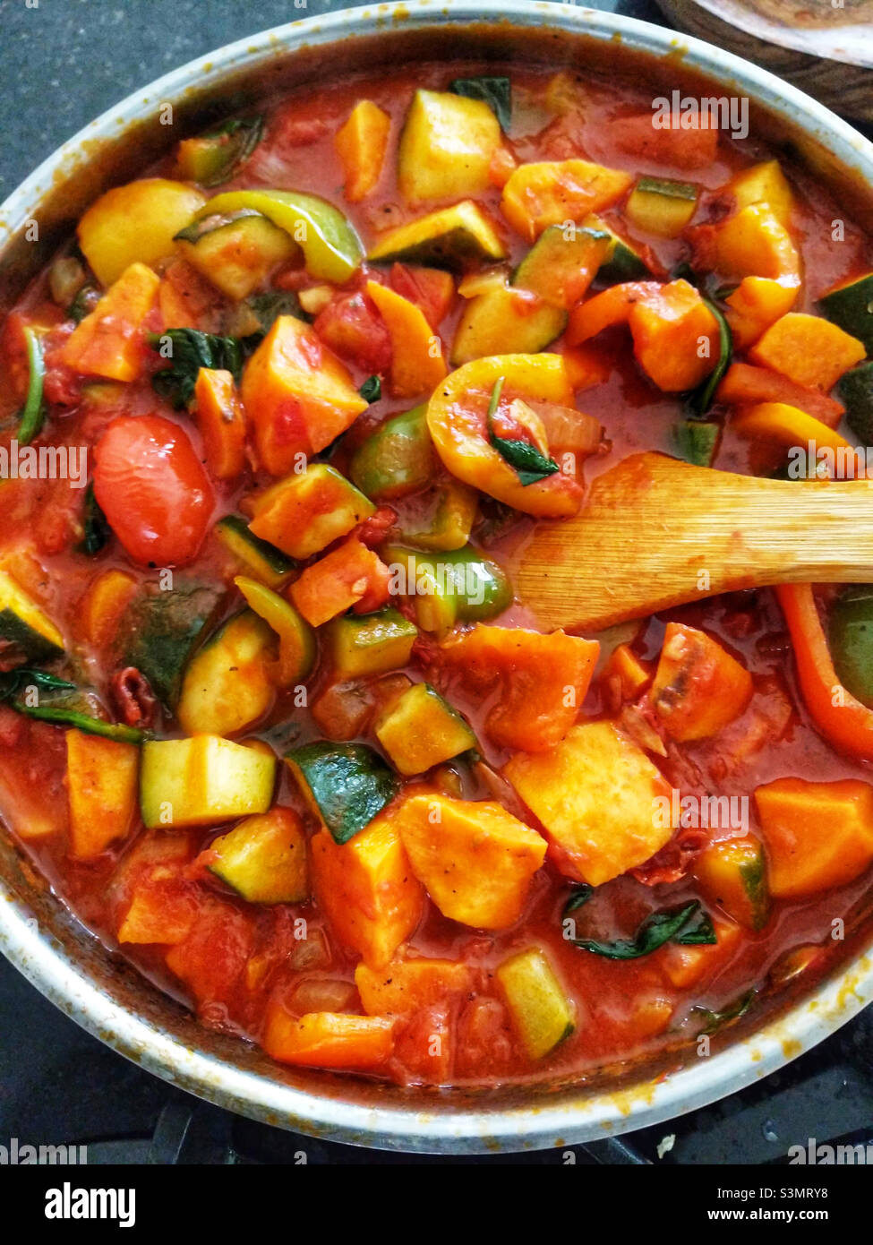 Vegetarian lasagne making big pan filled with cut vegetables in tomato