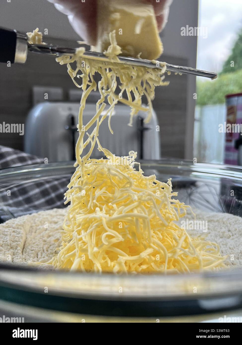 Grating butter into flour to make scones Stock Photo
