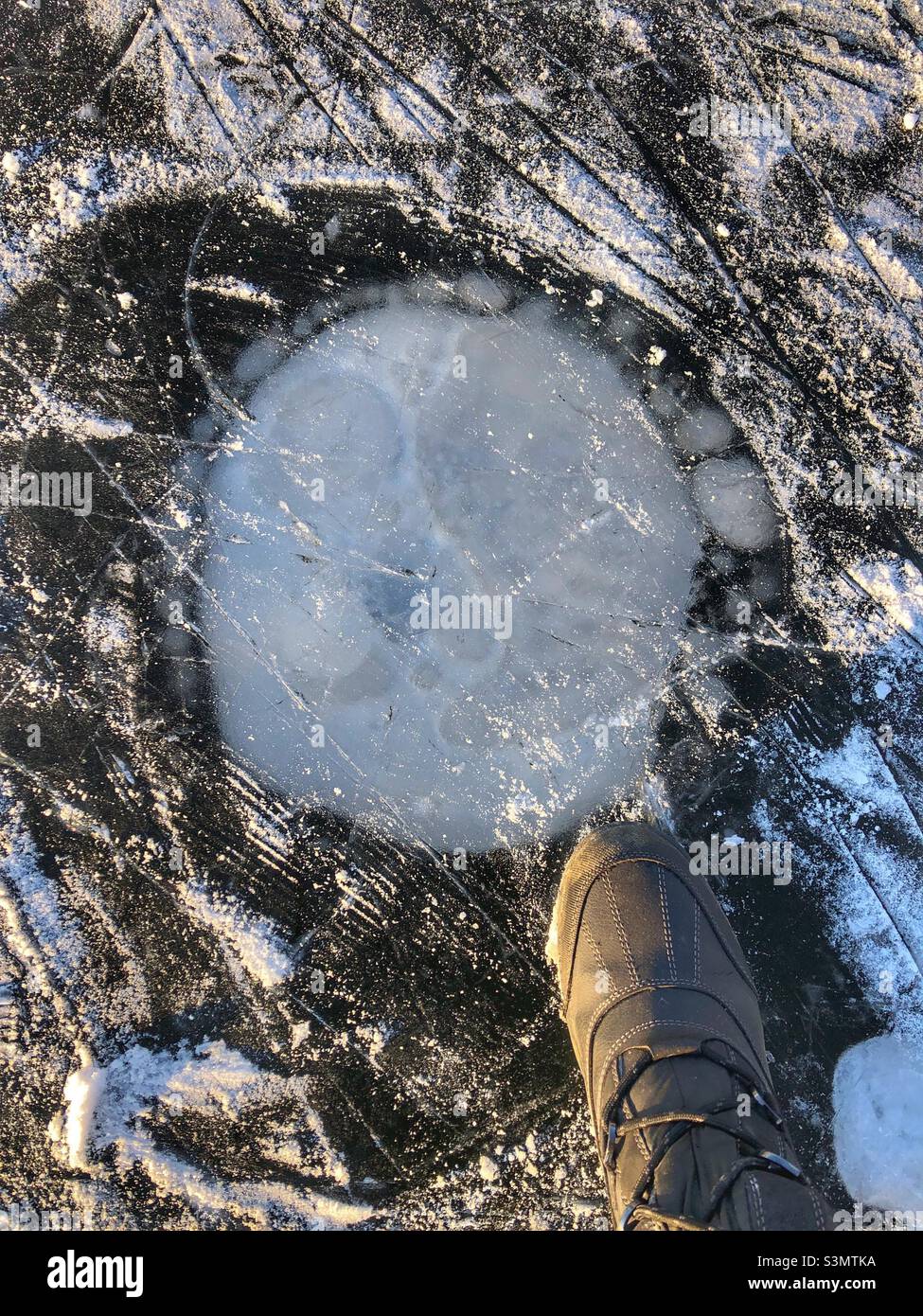Stepping on frozen ice on a pond. - Smartphone Captured Stock Image