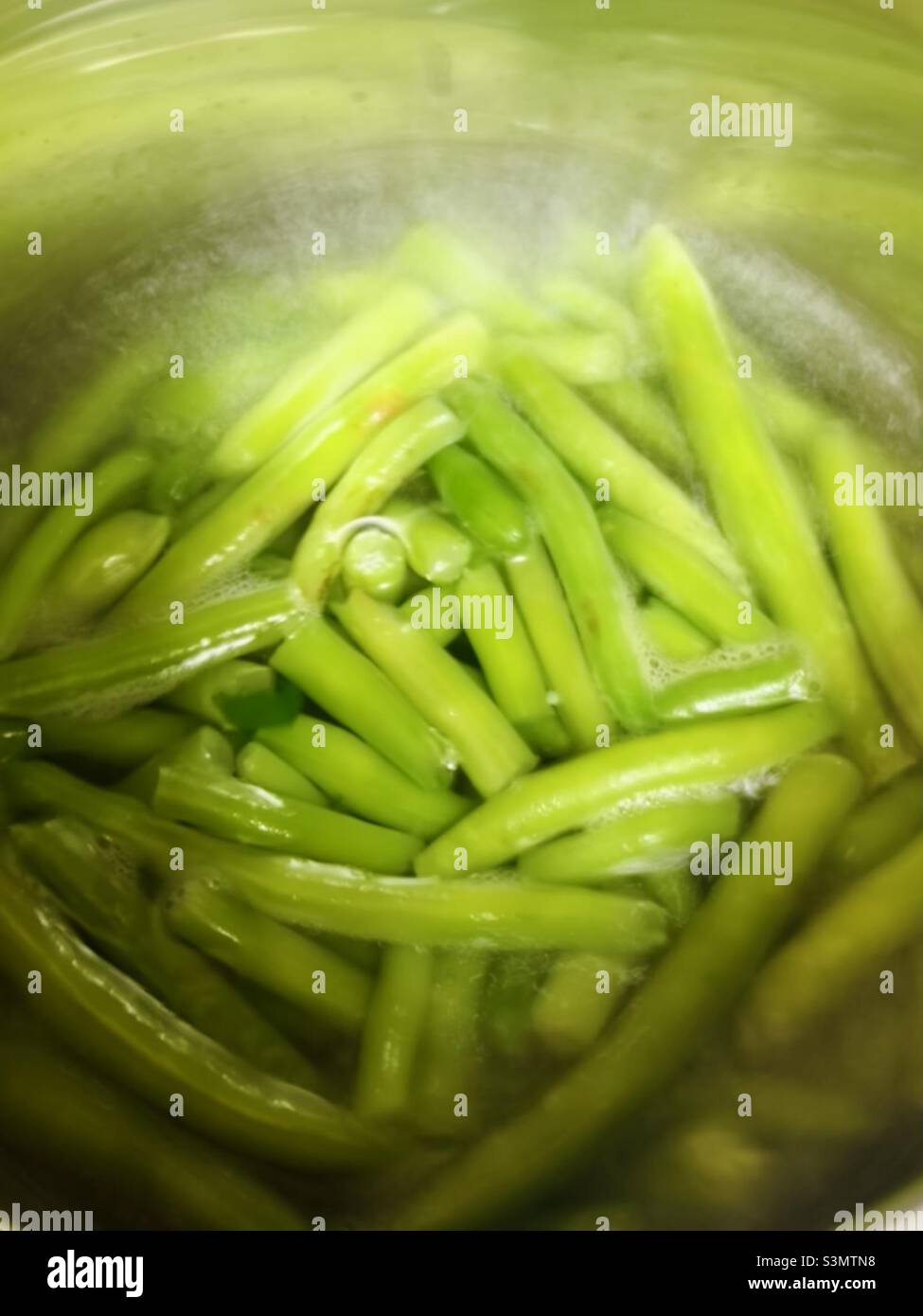 Green beans cooking in a saucepan of water Stock Photo