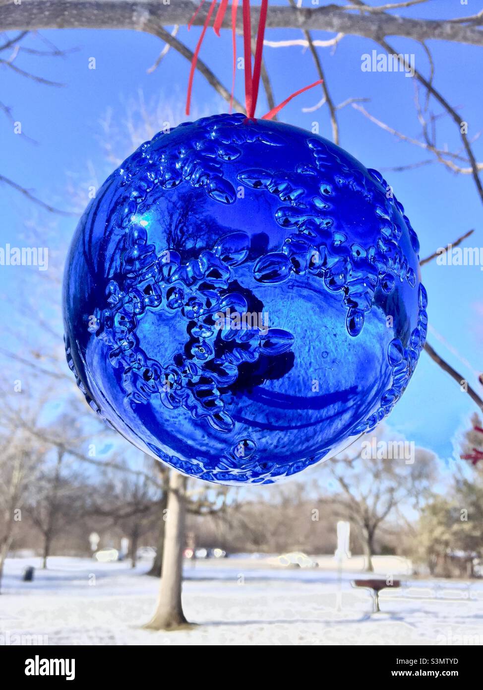 Blue orb in snow. Adding color to a snowy winter day, outdoors, snow on the ground, Ontario, Canada. - Smartphone Captured Stock Image
