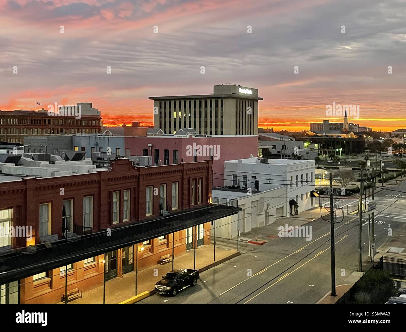 Sunrise in downtown Galveston, looking towards Gulf of Mexico, 1/4/2022.  This view is taken from Mechanic Street and shows Market and Post Office streets and local businesses. - Smartphone Captured Stock Image