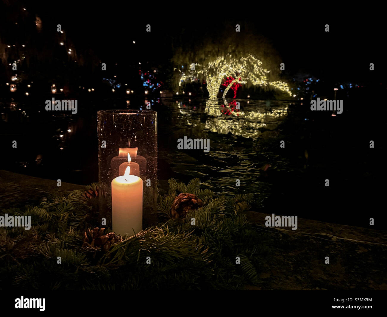 Single candle surrounded by a wreath along a reflecting pool at Brookgreen Gardens Nights of a Thousand Candles. Brookgreen Gardens, Murrells Inlet, South Carolina. Stock Photo