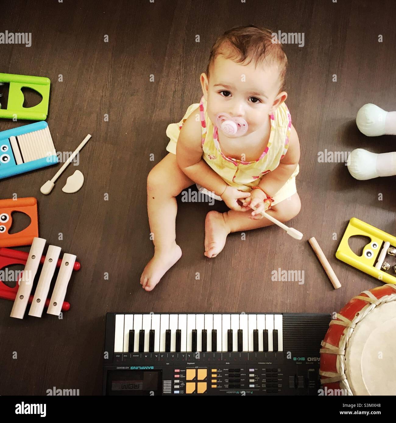 Baby girl among music instruments Stock Photo