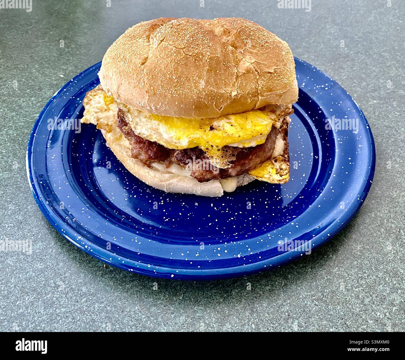 Sausage egg and cheese sandwich on a blue metal plate Stock Photo Alamy
