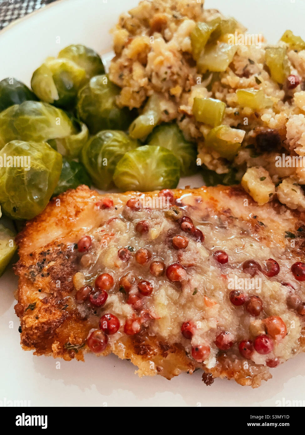 Close up of a breaded veal cutlet, brussels sprouts and cornbread stuffing, United States - Smartphone Captured Stock Image