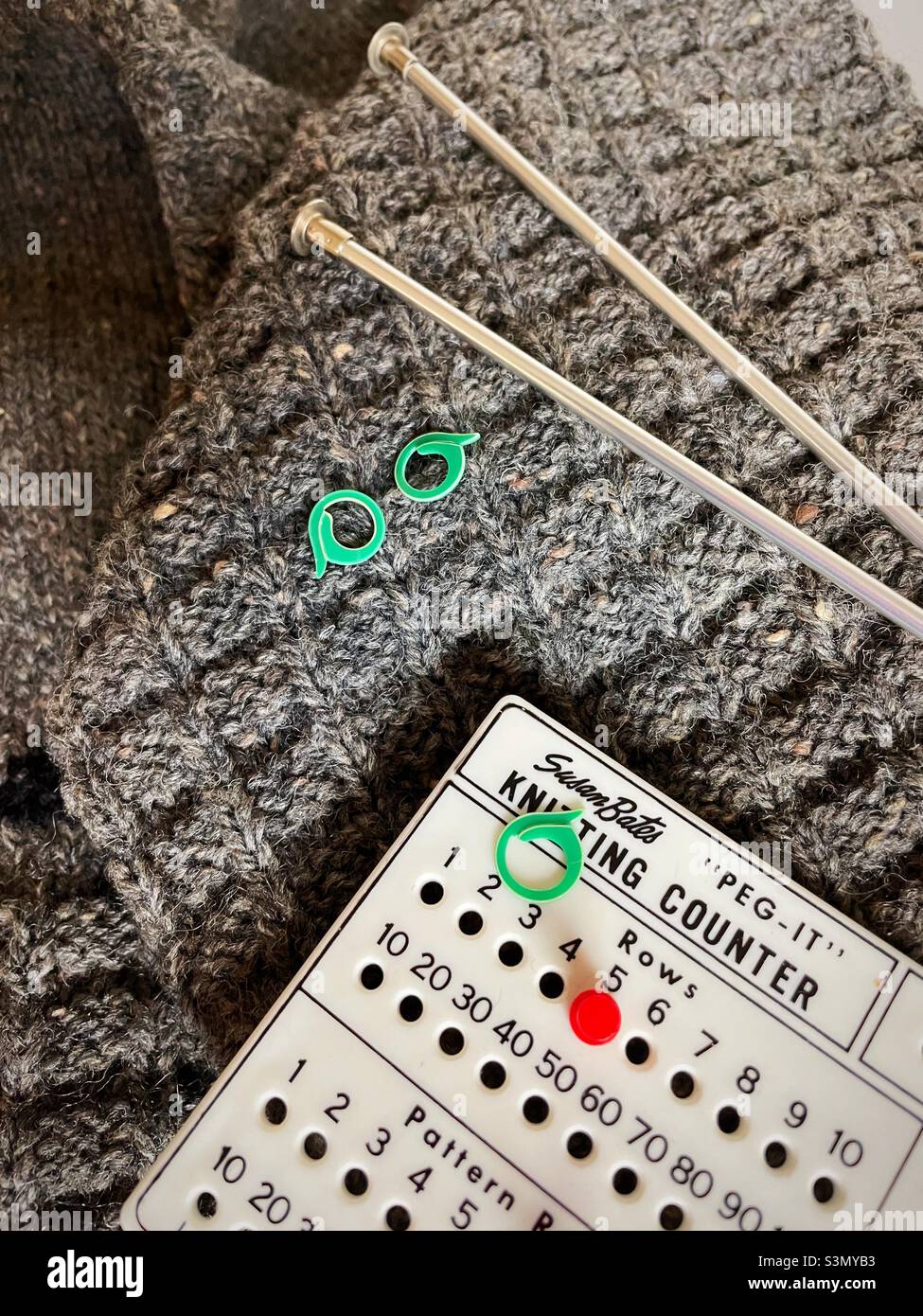 Close-up of a knitted gray sweater with a knitting needles and a stitch counter, 2022, United States - Smartphone Captured Stock Image