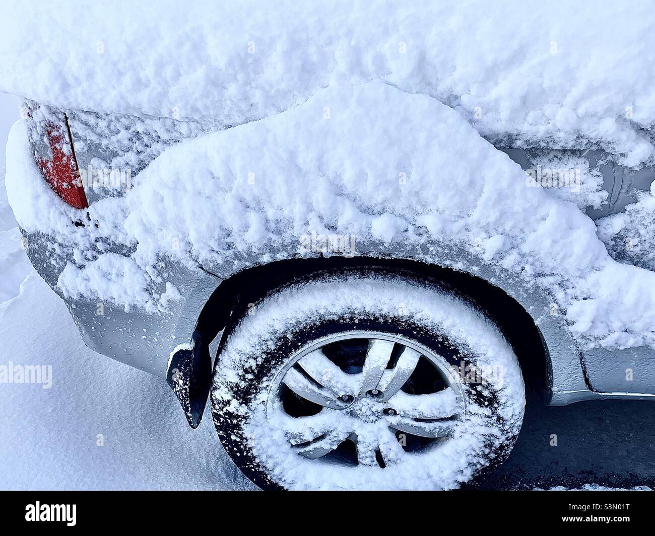 Morning after a heavy snowstorm drops a foot of snowfall in Utah, USA. This SUV was outside in a home’s driveway and is caked with the blowing snow from the night before. - Smartphone Captured Stock Image