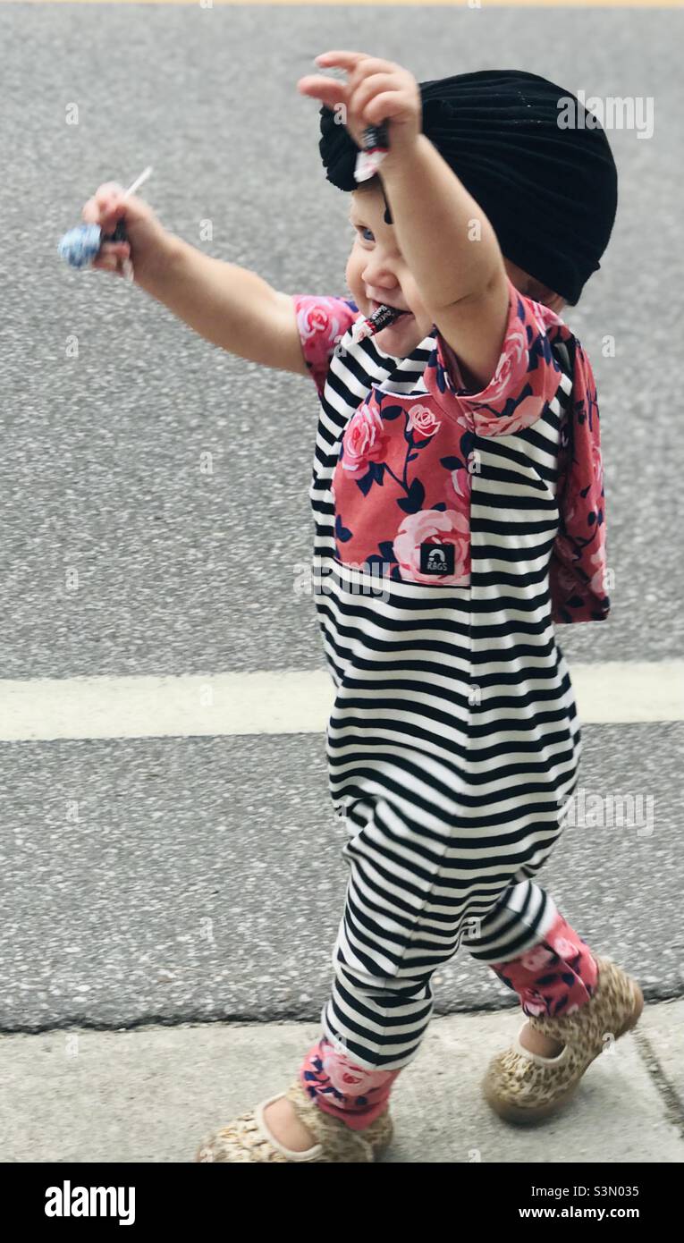 Baby girl collecting candy at a parade Stock Photo