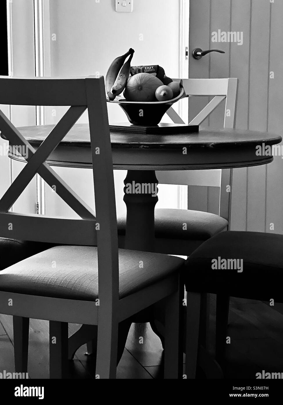 Black and white image of a furniture arrangement with fruit bowl - Smartphone Captured Stock Image