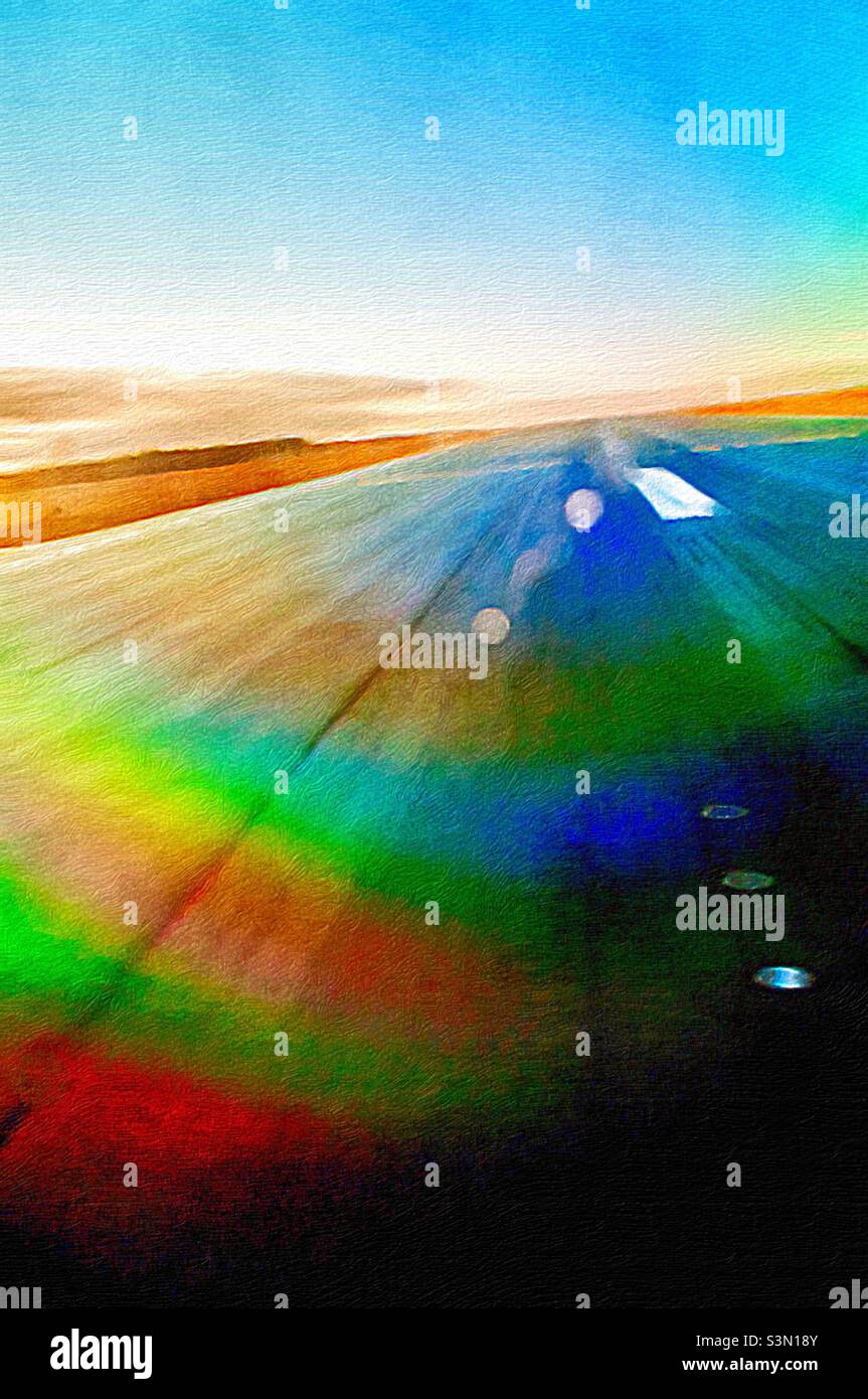 Modern runway at a large airport reimagined. No planes, no buildings, no vehicles. Blue sky. Rainbow of colours. Lights. Markings. Refracted light. Up up and away. - Smartphone Captured Stock Image