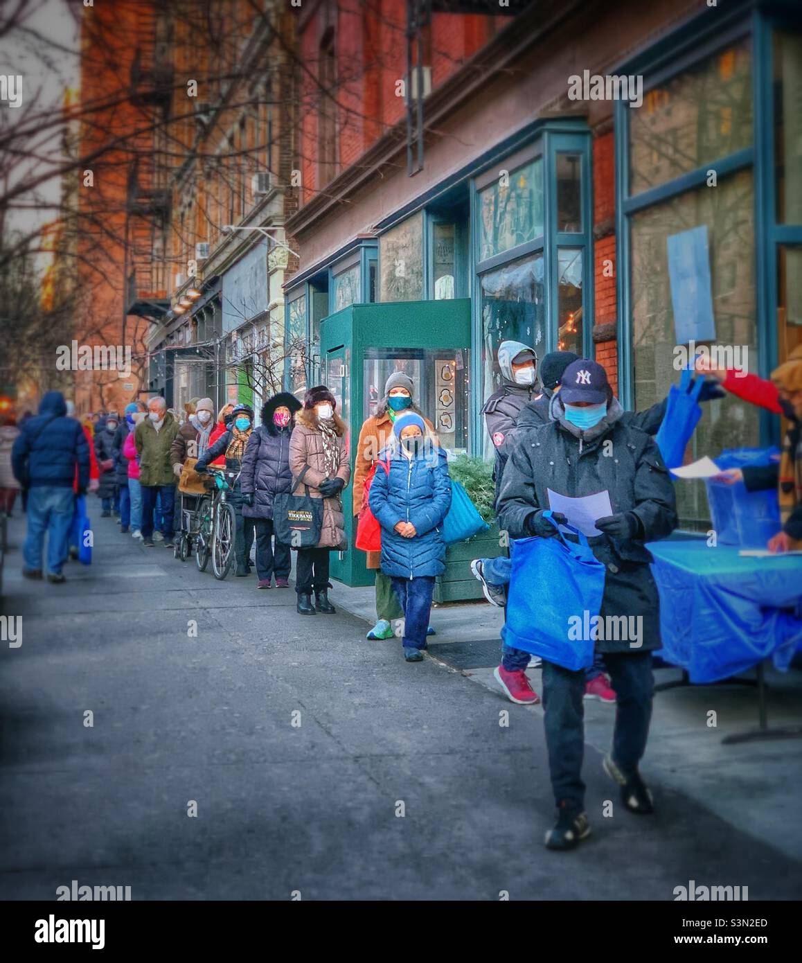 Residents line up to pick up free at home COVID-19 test kit at a distribution site in 88 street, Manhattan, New York City. January 26, 2022 - Smartphone Captured Stock Image