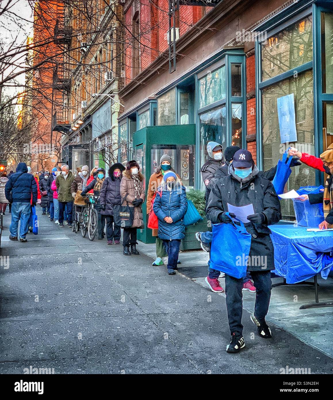 Residents line up to pick up free at home COVID-19 test kit at a distribution site between 88th and 87th street, Manhattan, New York City. January 26, 2022 - Smartphone Captured Stock Image