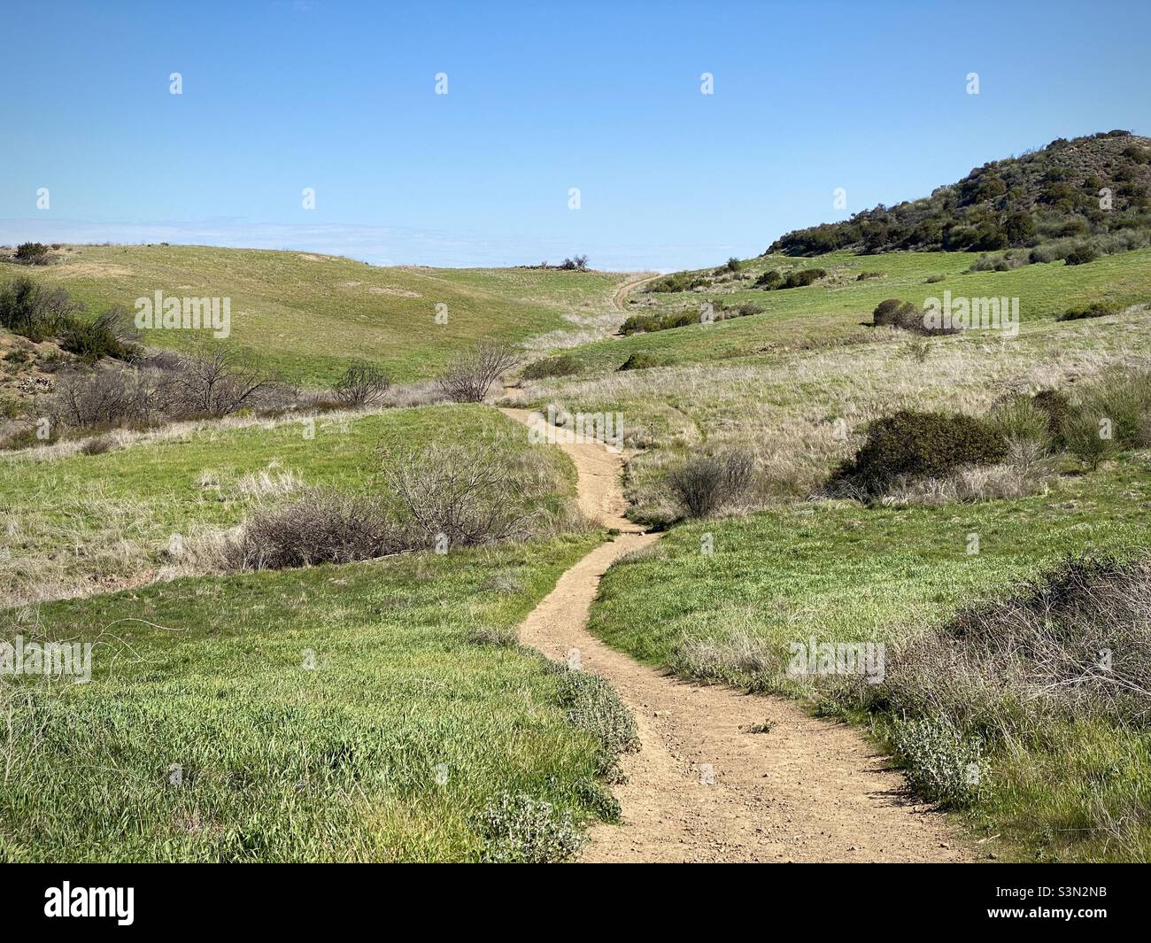 Winding hiking trail across grasslands at Rancho Sierra Vista, Newbury Park, California. Clear blue skies Stock Photo