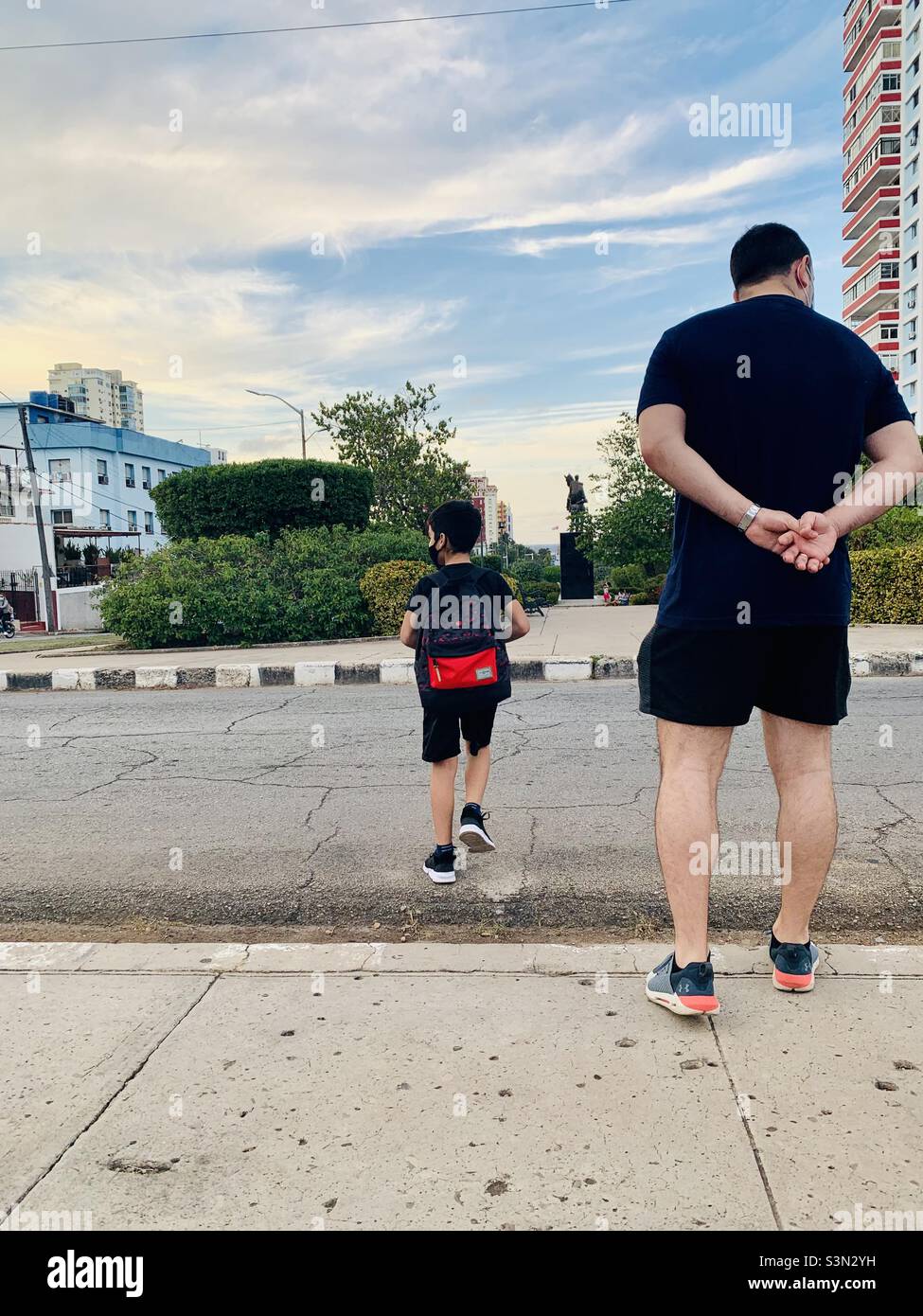Father supervising son crossing the road. Learning to cross the street safely. Fathering concept. Adult supervision concept Stock Photo