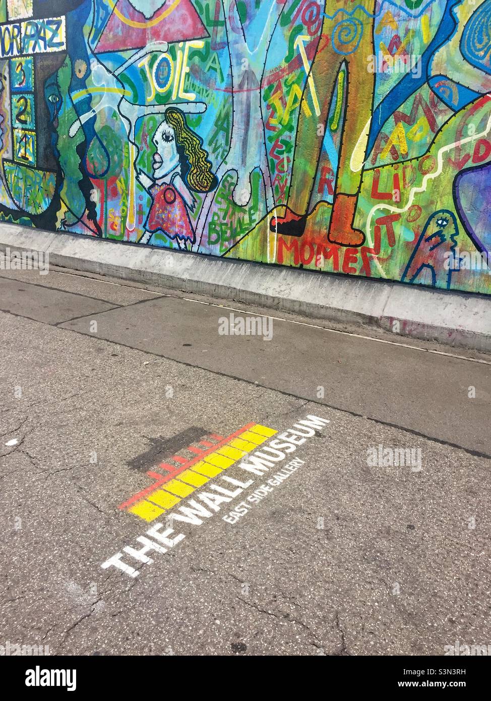 ‚The Wall Museum, East Side Gallery‘, Text written on sidewalk. Longest surviving section of the Berlin Wall, Germany Stock Photo