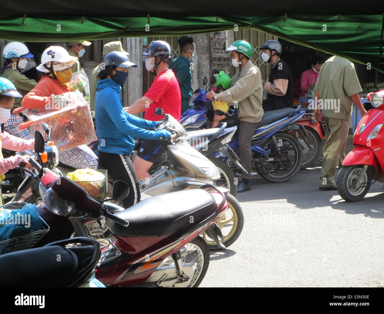 Police (in green shirt) inspect flower shops on Le Van Phan Street, Phu Thuy, Phan Thiet, Binh Thuan, Vietnam (29 January 2022 at 11h35) - Smartphone Captured Stock Image