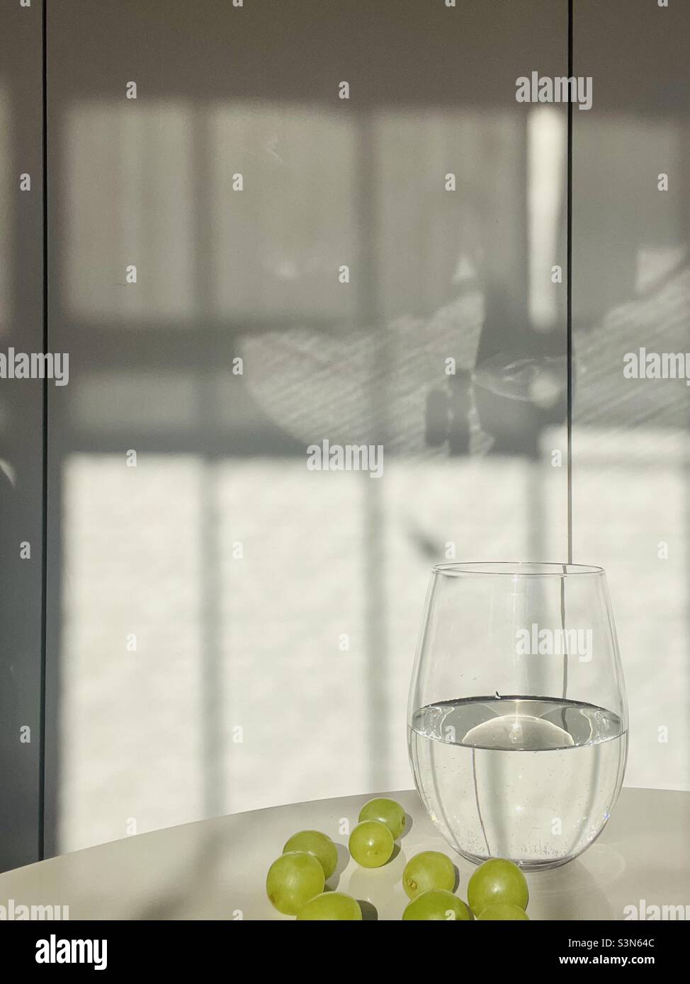 A glass of water and green grapes - Smartphone Captured Stock Image