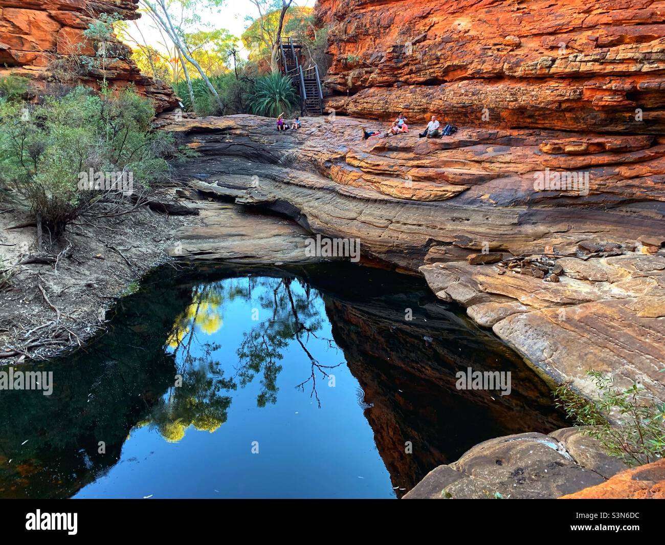 Hikers relax at a waterhole deep in Kings Canyon, Northern Territory, Australia Stock Photo