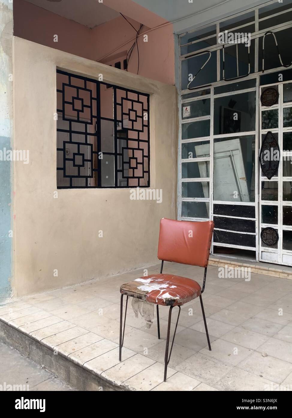 Empty seat on doorway of government office in Havana, Cuba. - Smartphone Captured Stock Image