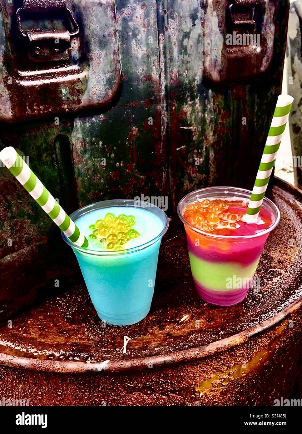 Pretty, colorful frozen adult beverages at Disney’s Animal Kingdom, Pandora / Avatar / Na’vi / flight of passage section, eco friendly paper straws Stock Photo
