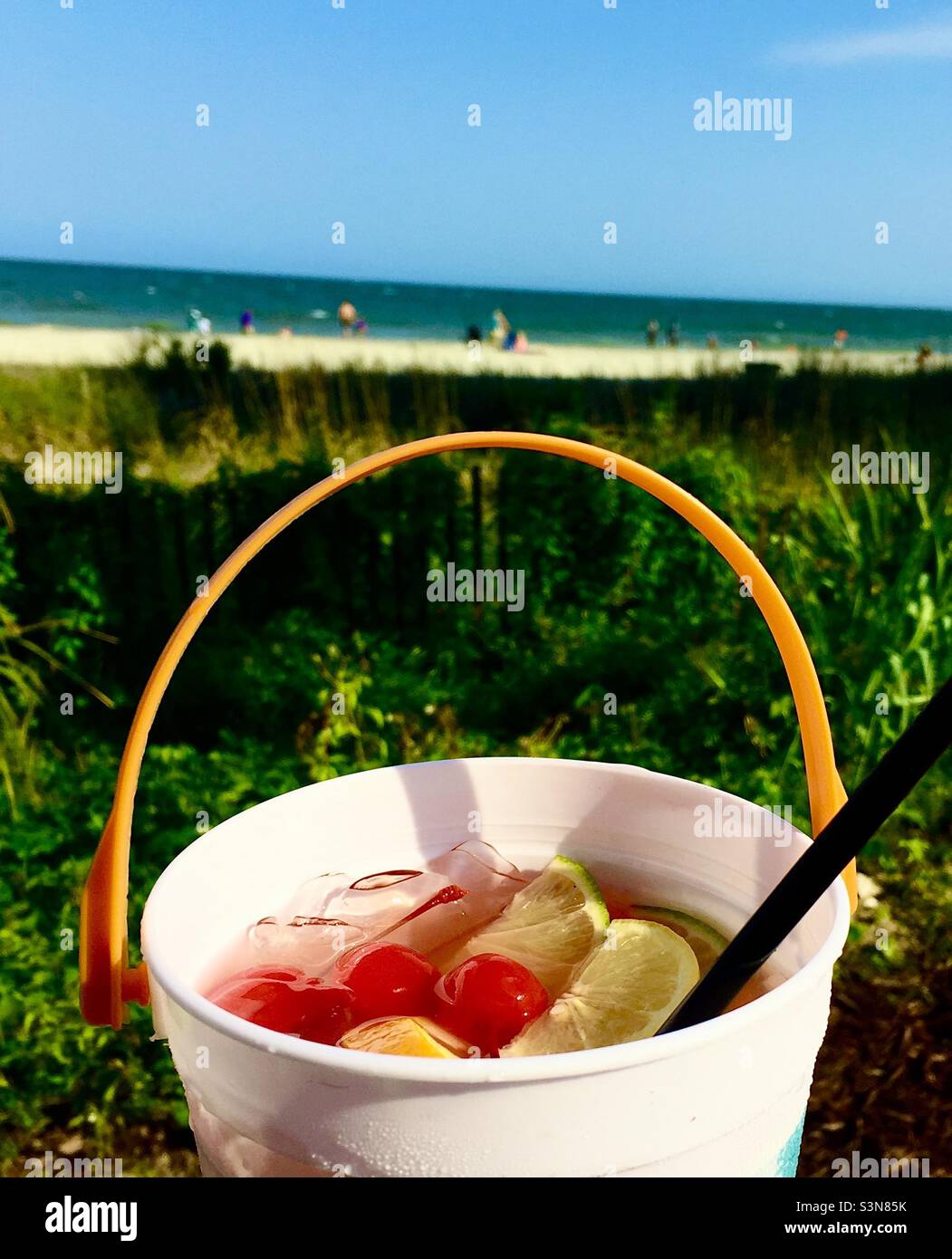 Beach drink Fruity bucket drink with a beach grass, sand and ocean background Stock Photo Alamy