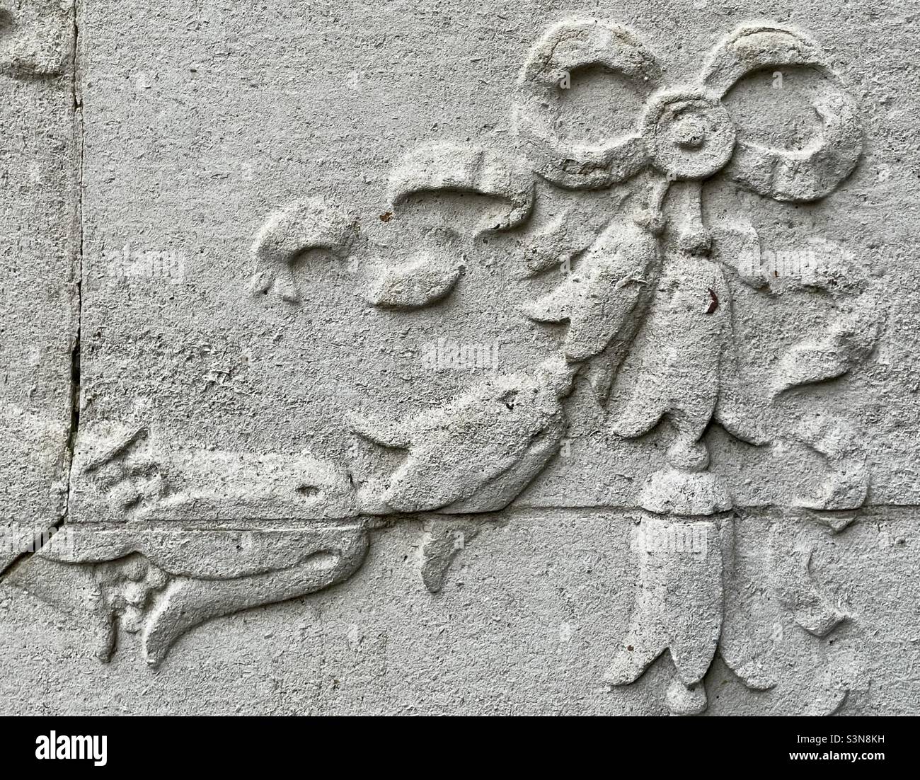 A detail of classical ornament using ribbon and husk in a swag on the facade of an old bank building in Worcester - Smartphone Captured Stock Image