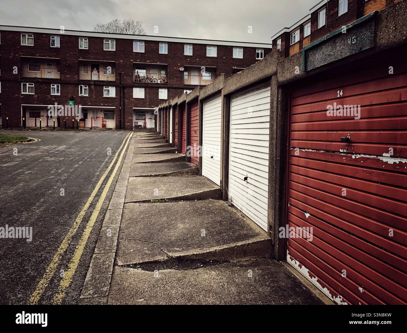 Run down garages and apartment blocks in a northern town of England before the UK levelling up scheme Stock Photo