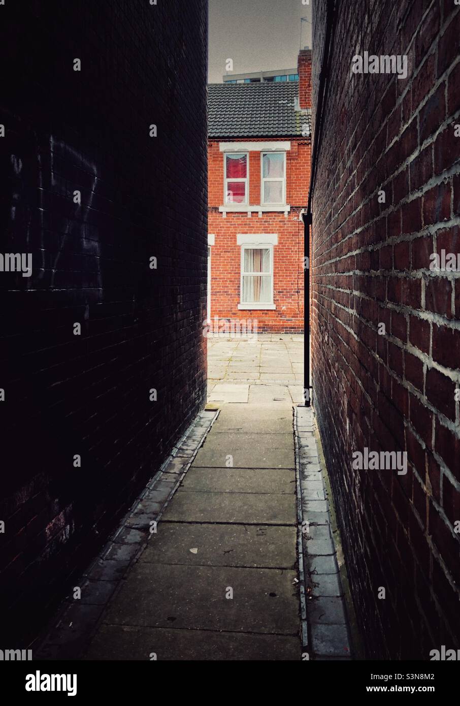 Rows of rundown terraced houses in the north of England and back alleyways with graffiti and copy space Stock Photo