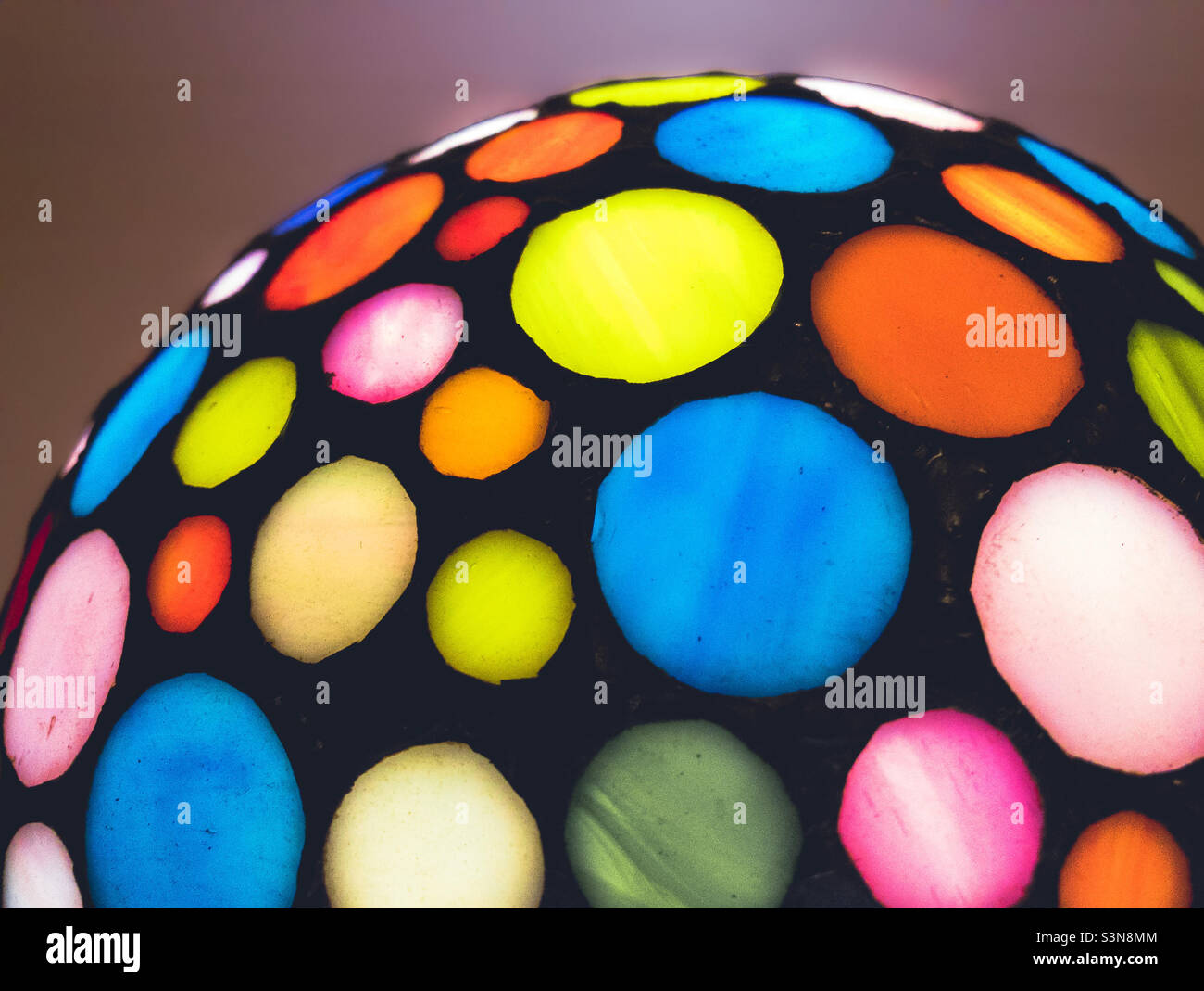 Part of a Tiffany style lamp, with coloured circles of stained glass - Smartphone Captured Stock Image