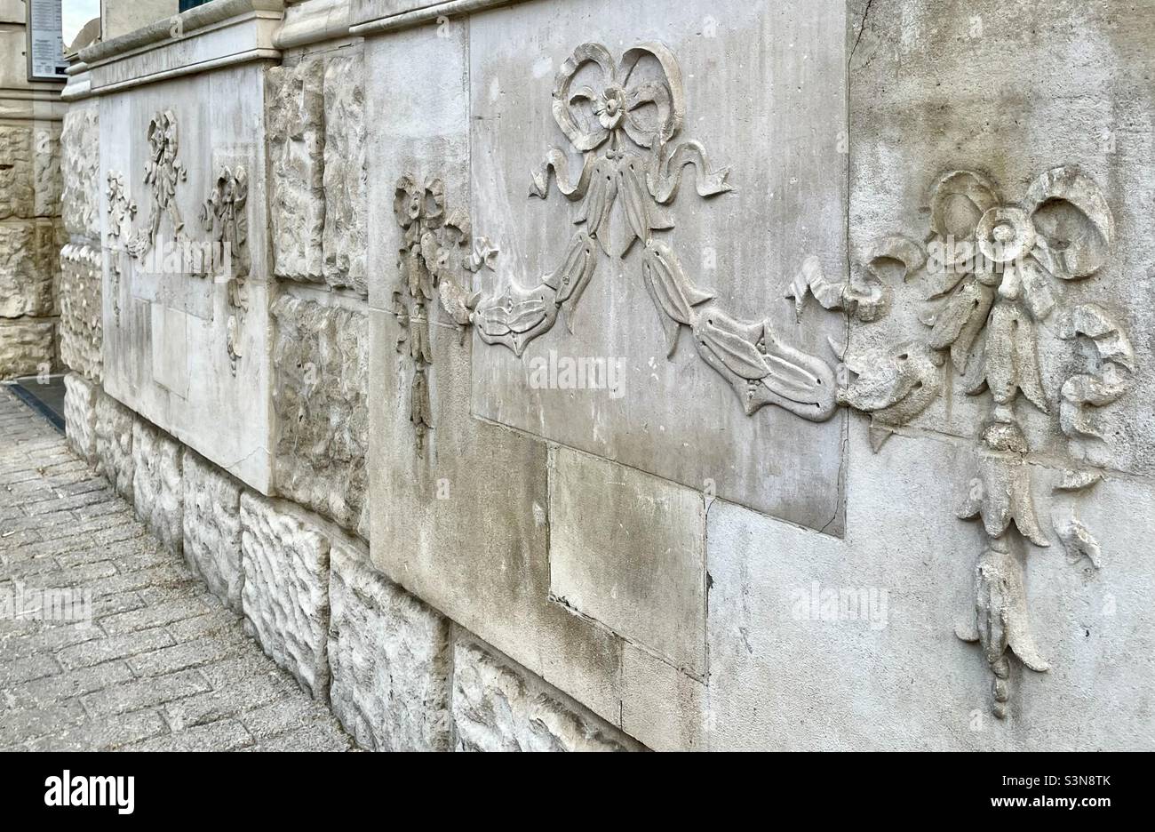 A relief carving on the front of an old bank building showing swags of classical husks and ribbons in Worcester - Smartphone Captured Stock Image