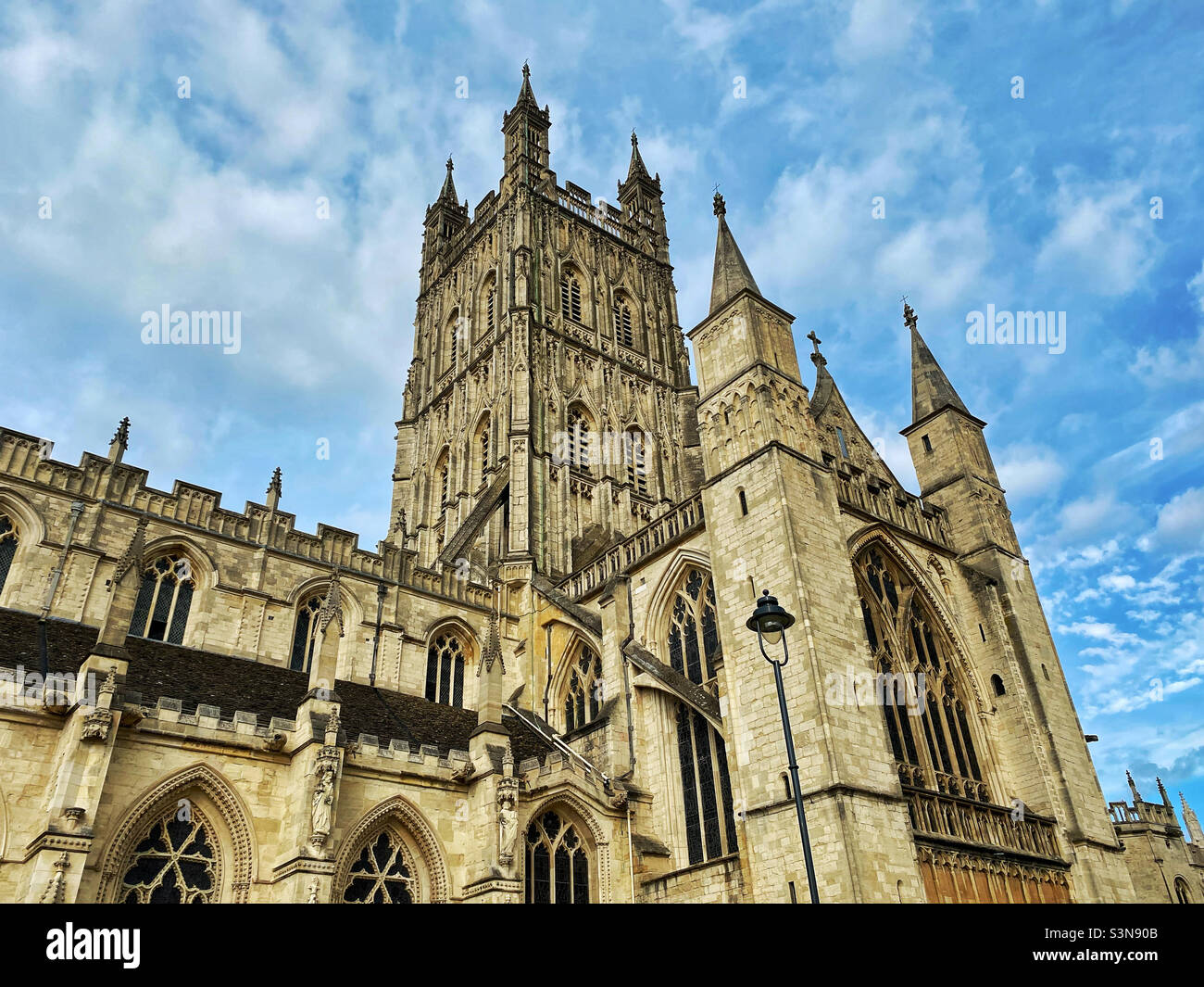 The exterior view of Gloucester Cathedral in southern England, UK. Visible is the 225ft tower & South Transept. Gloucester Cathedral houses the tomb of King Edward II. Photo ©️ COLIN HOSKINS. - Smartphone Captured Stock Image